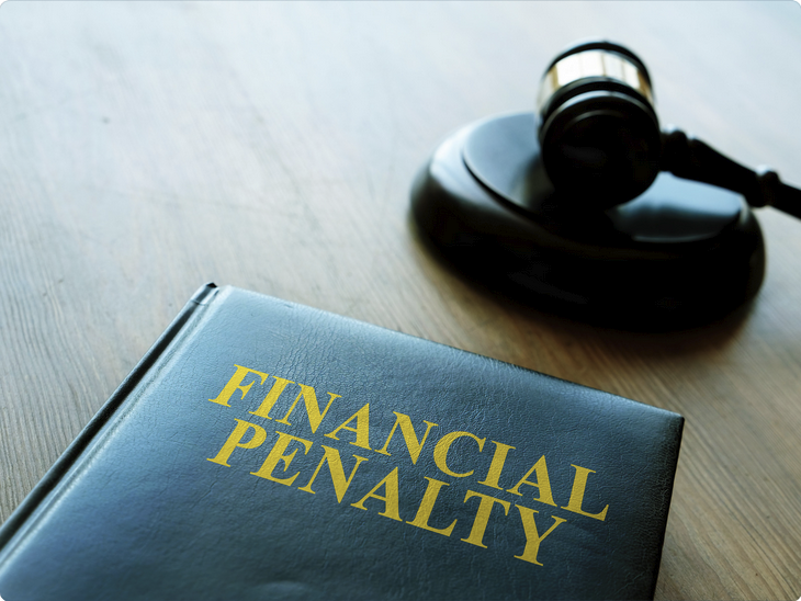 Close-up of a book titled "Financial Penalty" with a gavel in the background, symbolizing legal consequences and fines.