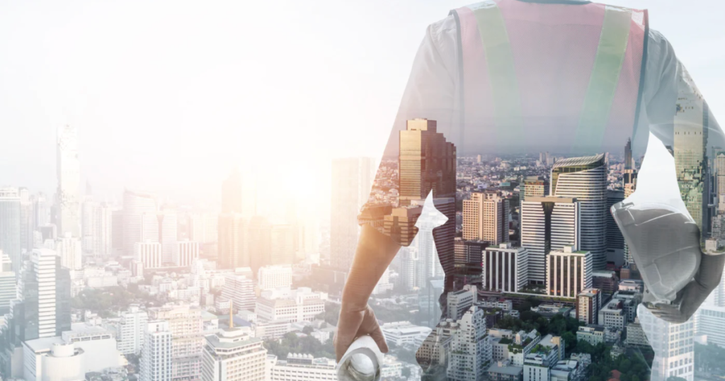 A creative double exposure image showing a construction worker in a safety vest overlaid on a cityscape, symbolizing urban development.